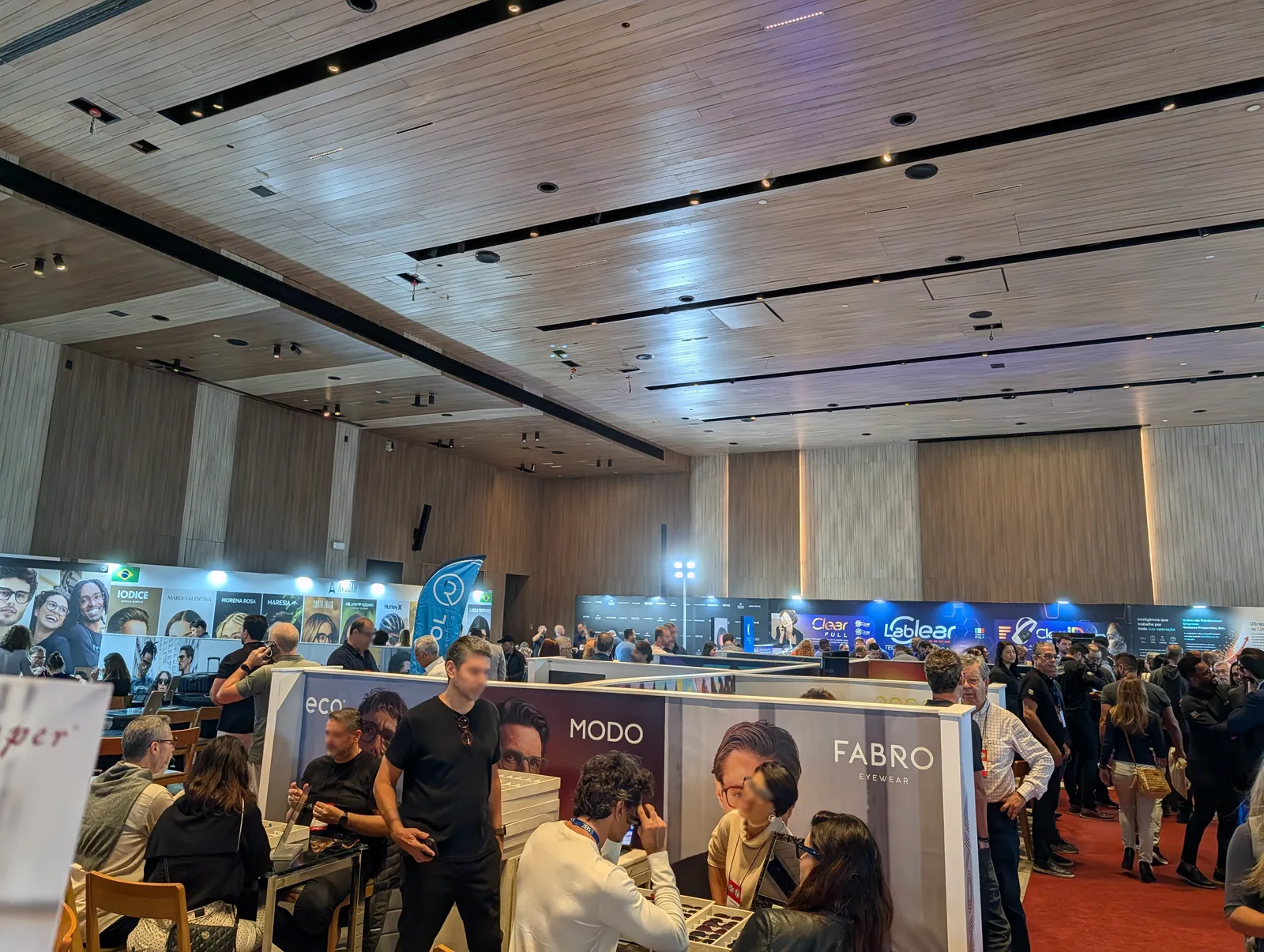 Salão da Expo Visão 2026 no Grand Hyatt, na Barra da Tijuca, com estandes de armações e visitantes circulando entre os corredores
